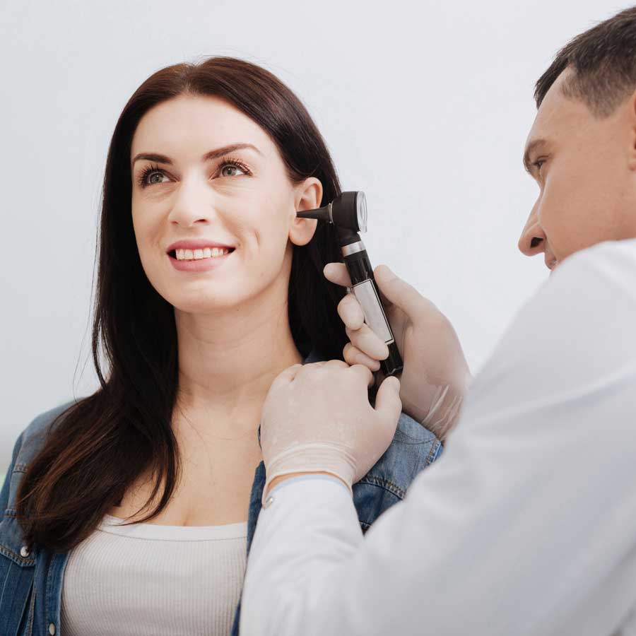 Hearing Expert examining a woman's ear